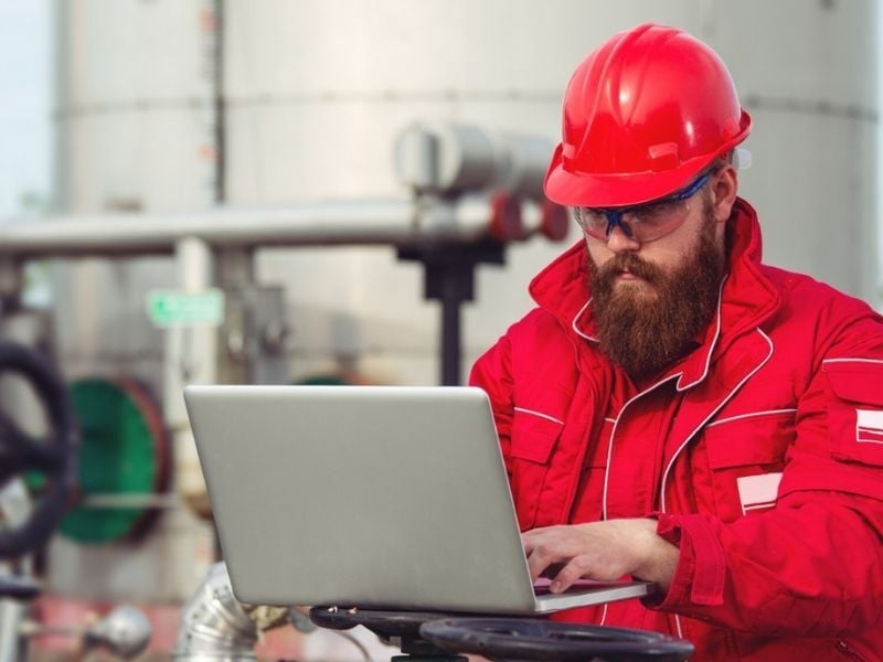 Engineer at an oil refinery using laptop