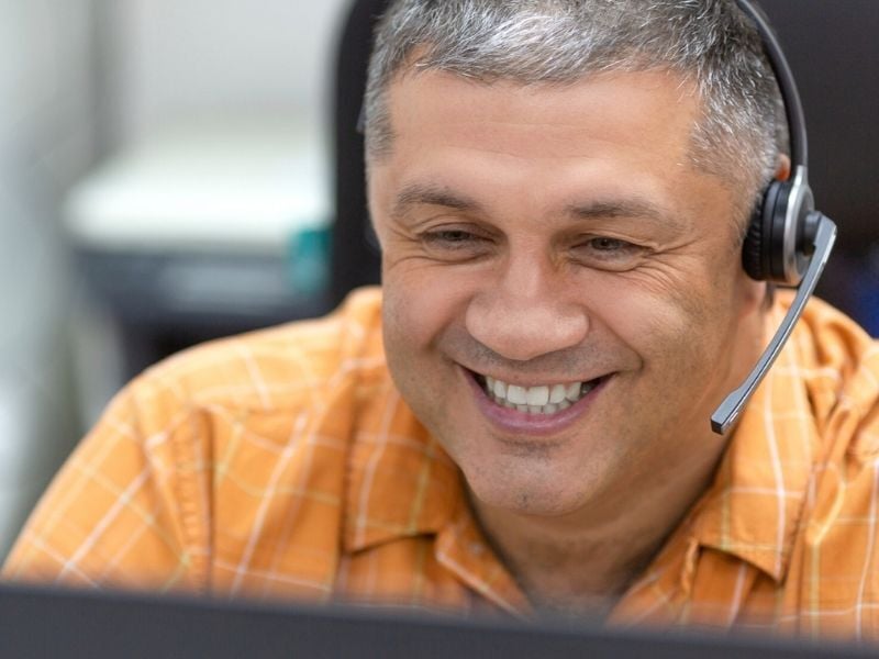 A support agent wearing a headset and resolving issues with a customer