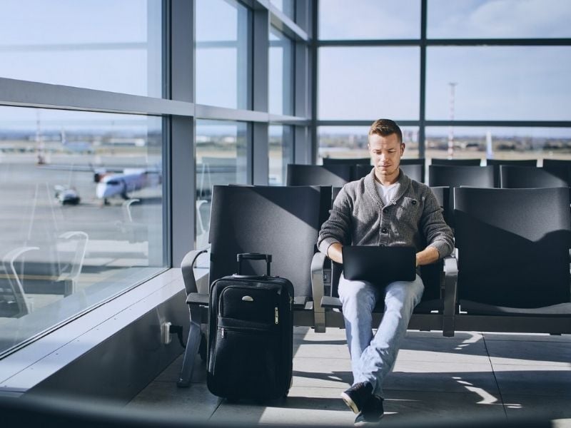 Travelers using laptop in airport