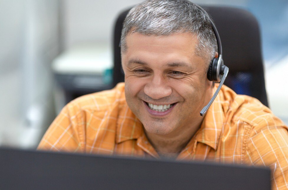 Man in orange shirt with headset