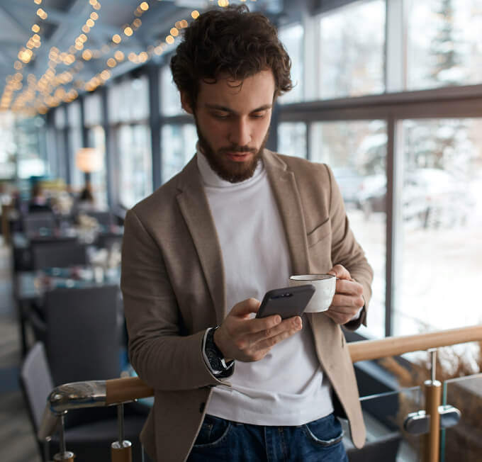 man-on-phone-holding-coffee